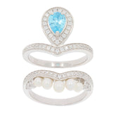 Pear-shaped blue topaz ring set in sterling silver with a band of pearls and accent diamonds.